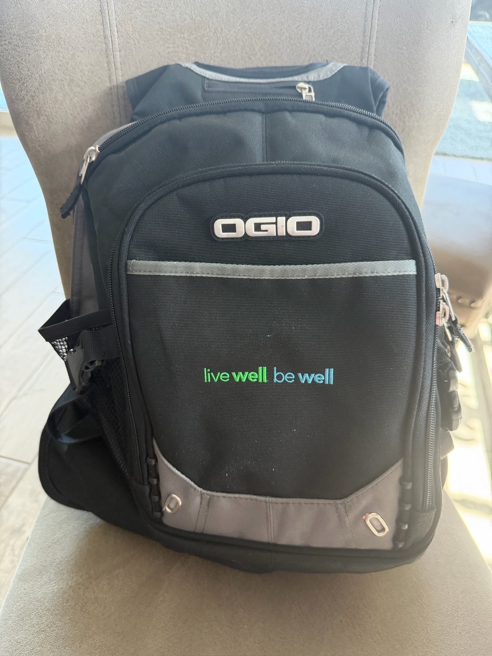 OGIO Black and Gray computer Backpack with Blue-Green "live well be well" Accent